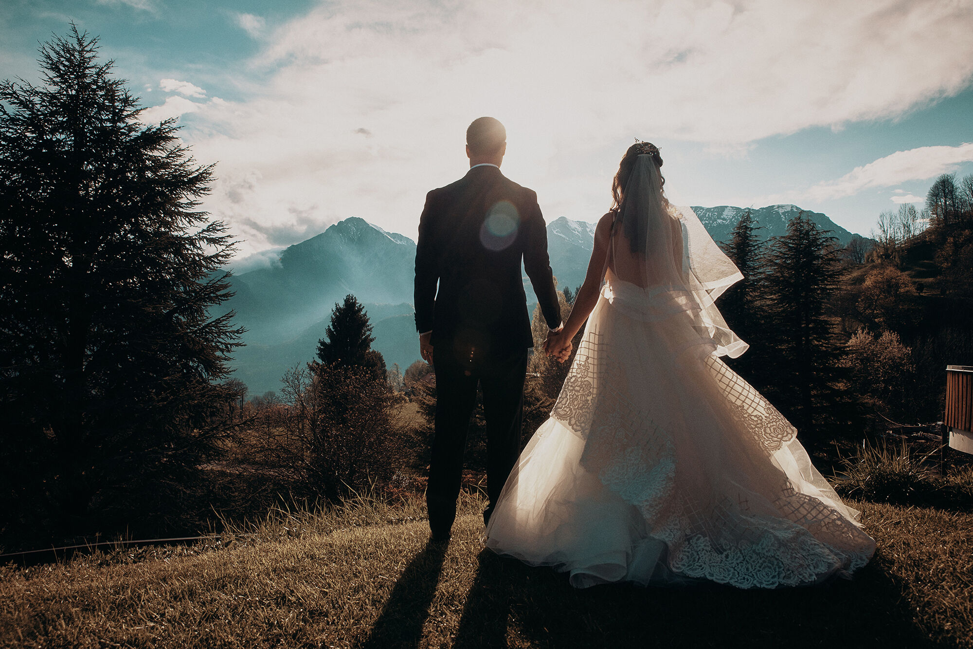 Sposi di spalle davanti alle montagne al tramonto, reportage di matrimonio BIG Photography